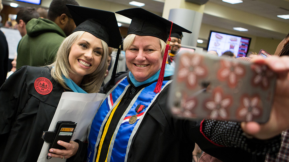 Two Cal U graduate students pose for a picture during Commencement.