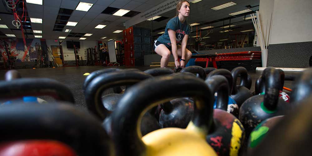 A Group Fitness and Leadership student uses a kettle ball.