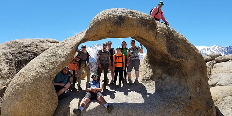 Students pose on geology rock formation.