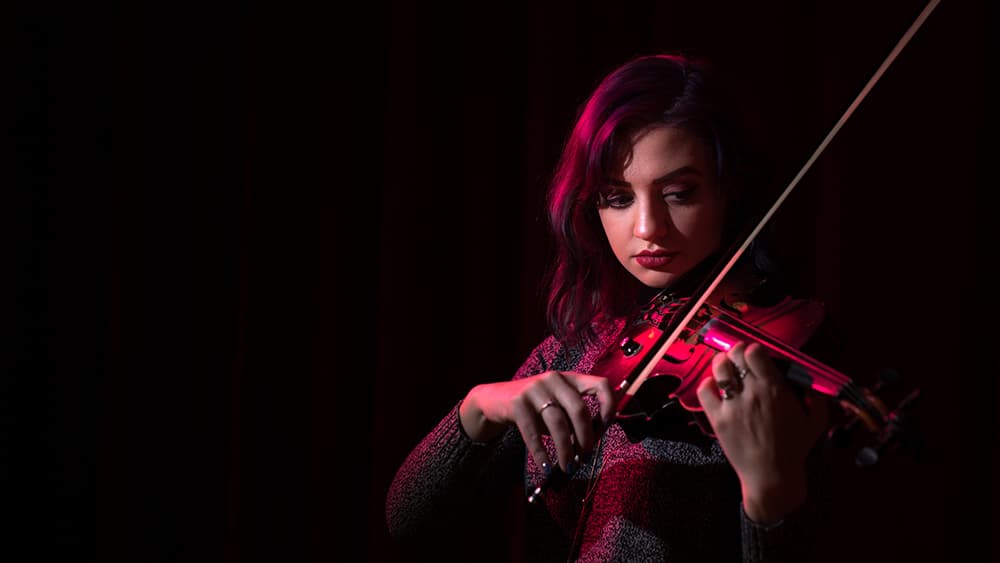 A Music Business Degree student plays the violin.