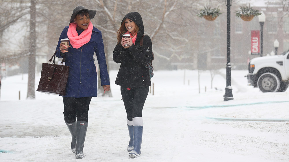 Two Cal U students walk outside on a winter day.
