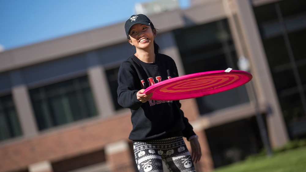 A Cal U student throws a frisbee.