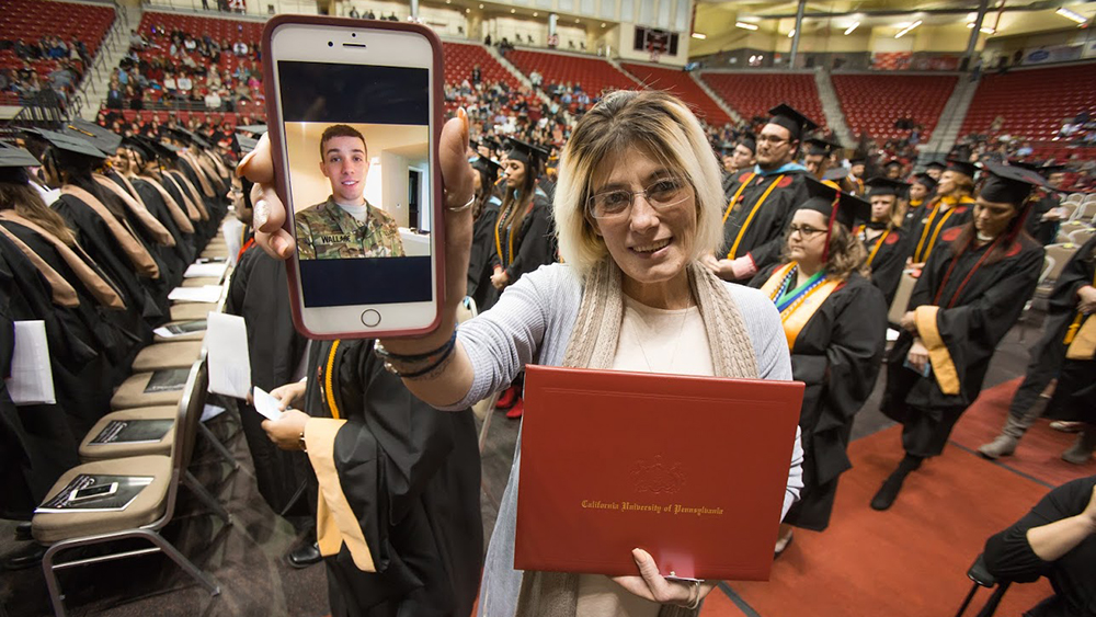 An active military student receives diploma via video conference.
