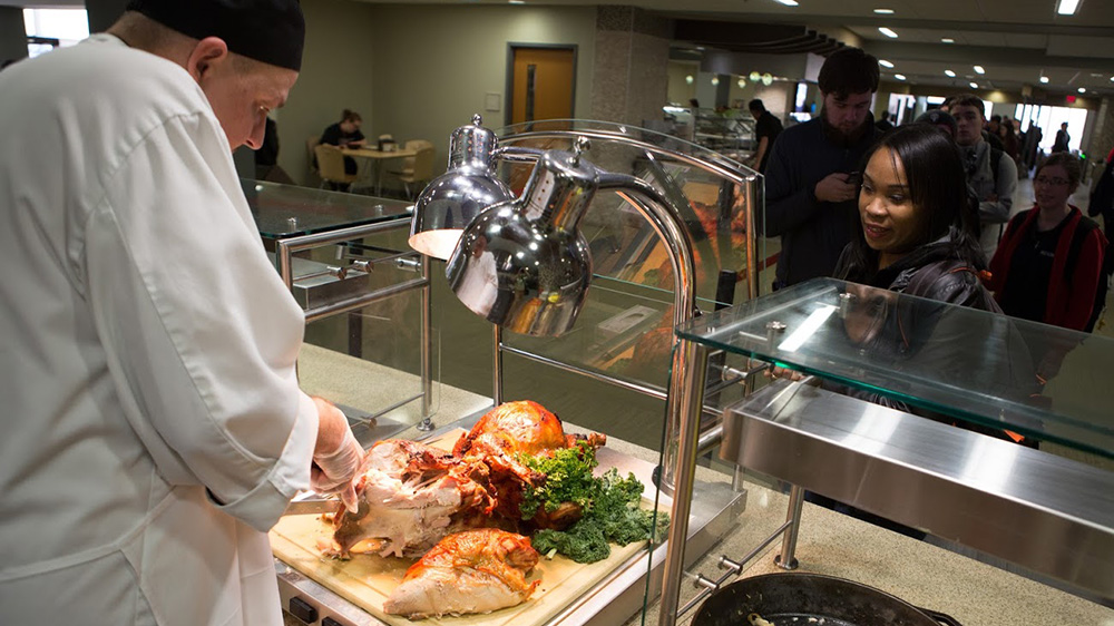 A chef serves food at PennWest California.