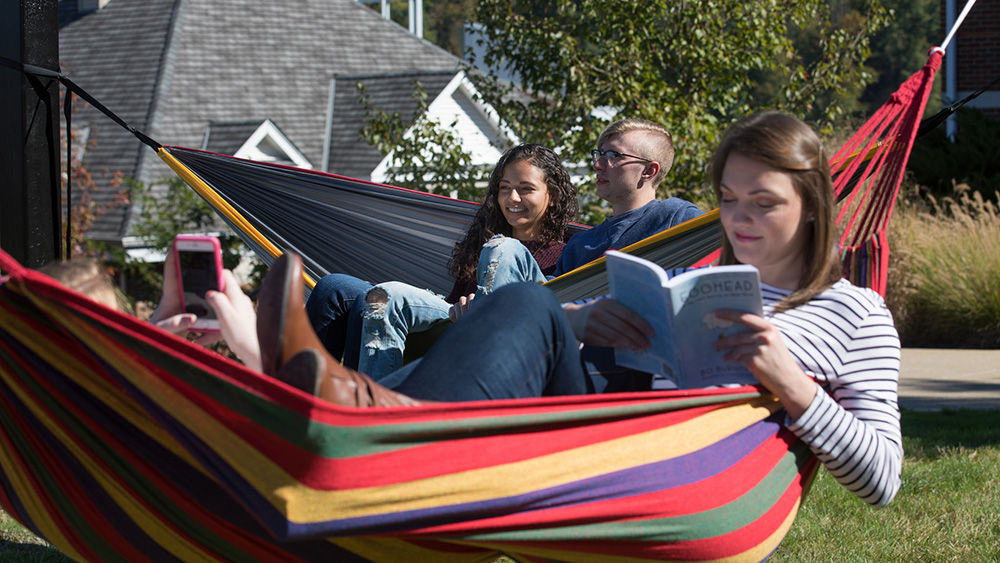 Students sit in a hammock.